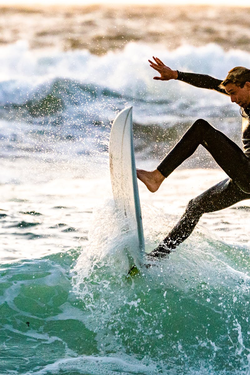 Energetic surfer performing a trick on ocean waves, showcasing skill and excitement.